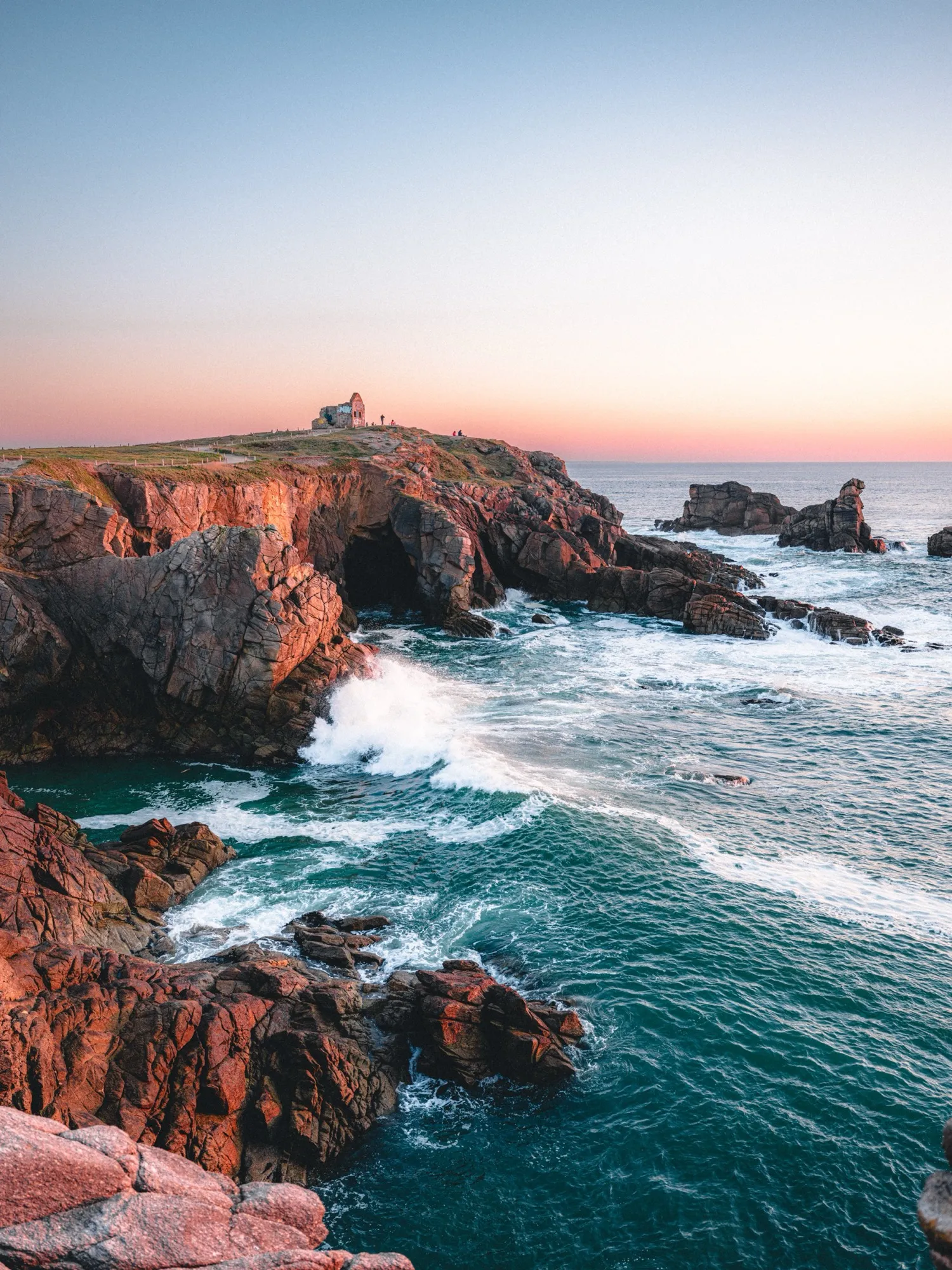 Les rochers rouges de la côte sauvage au coucher du soleil