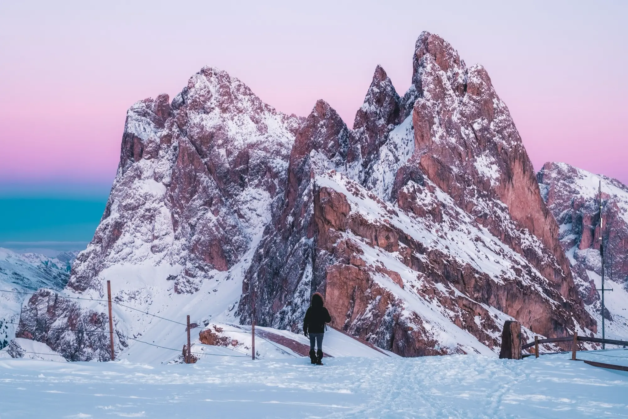 Un randonneur dans la neige au pied des aiguilles des Dolomites, à l'aube
