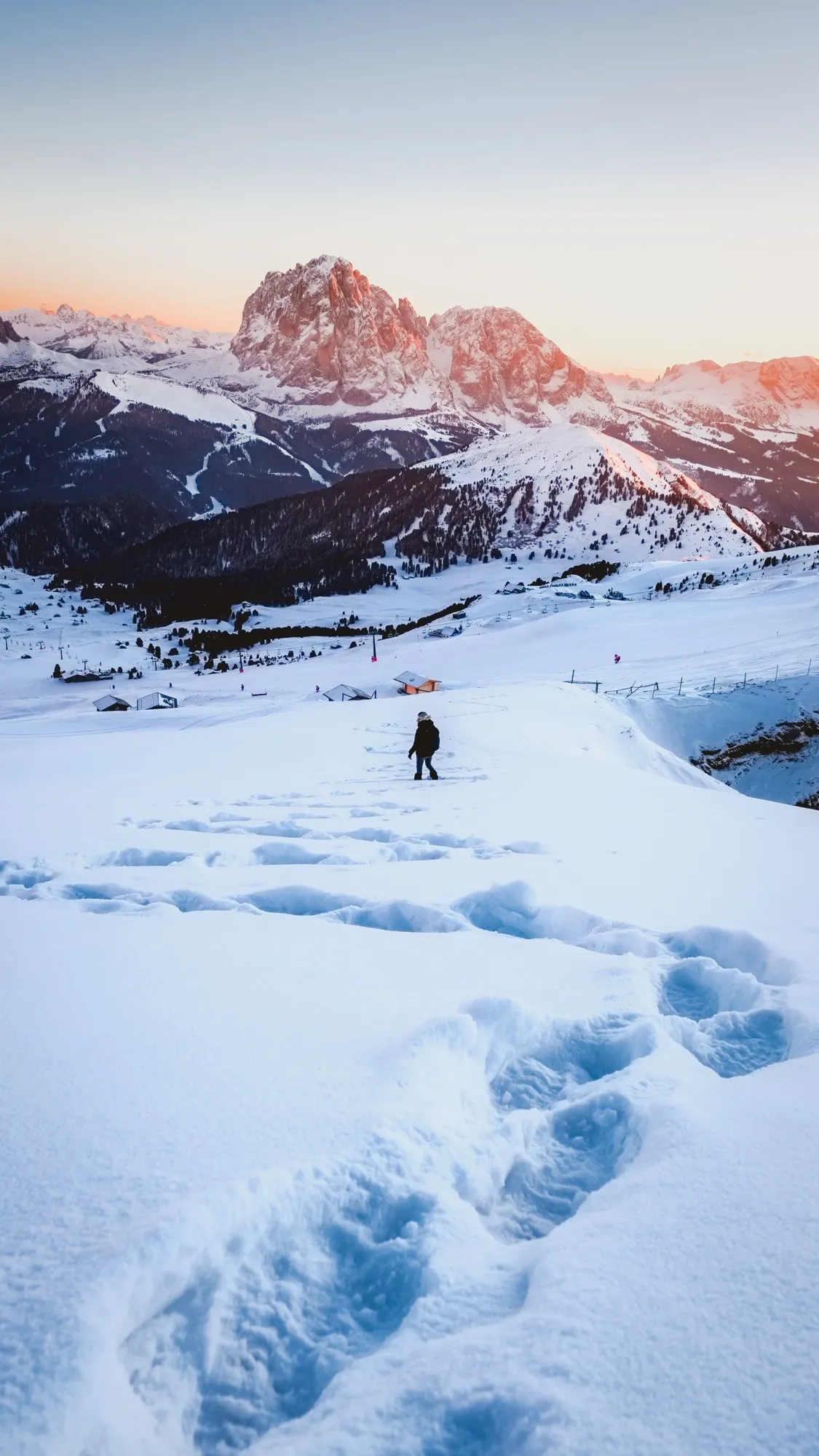 Des traces de pas dans la neige face aux Dolomites