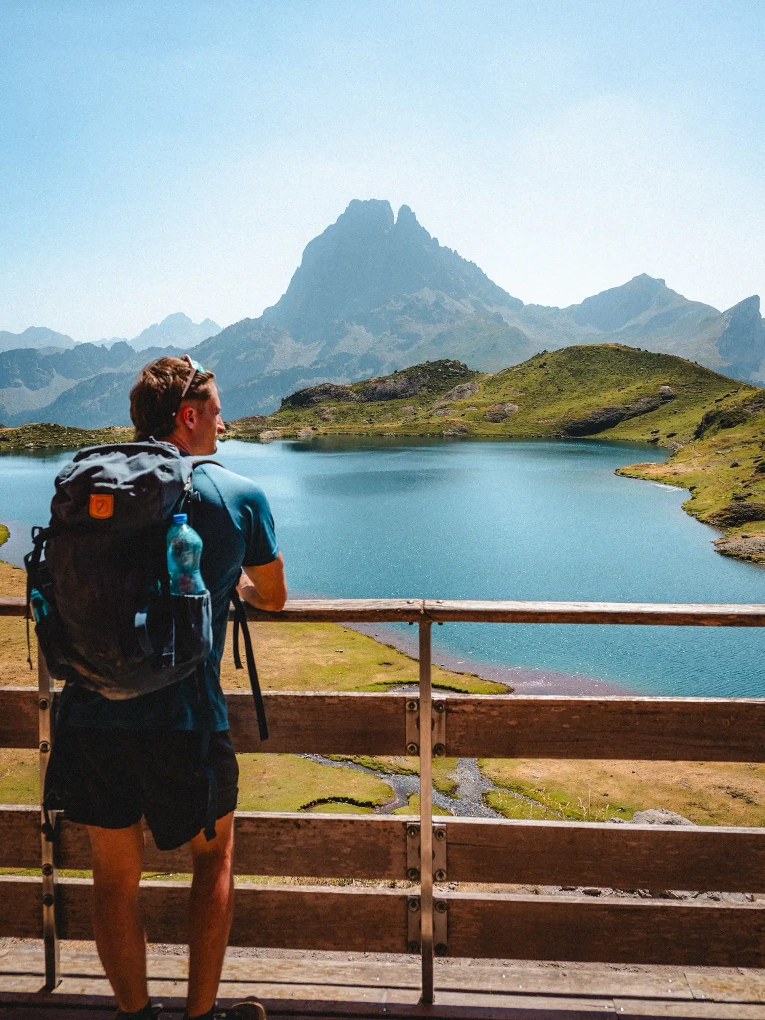 Un randonneur sac au dos face au Pic du Midi d'Ossau et à son lac